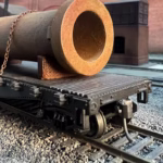 Photo of an HO Scale 3D printed model of a large rusty water pipe for a model railroad