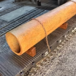 Photo of an HO Scale 3D printed model of a large rusty water pipe for a model railroad
