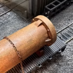 Photo of an HO Scale 3D printed model of a large rusty water pipe for a model railroad
