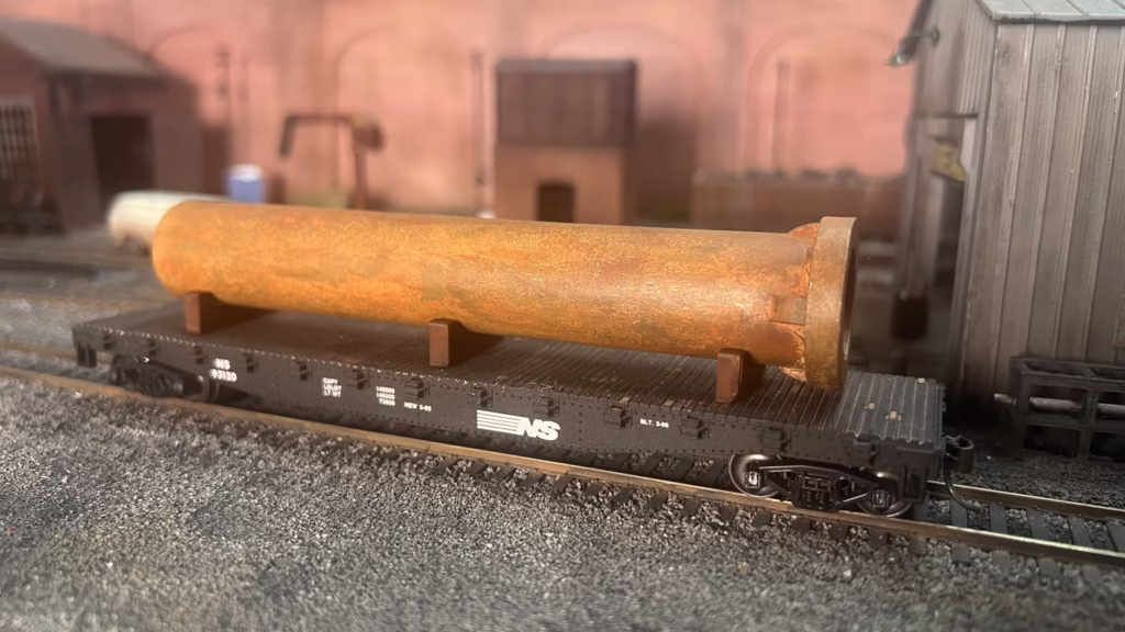 Photo of an HO Scale 3D printed model of a large rusty water pipe for a model railroad
