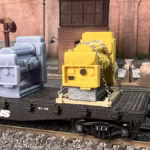 HO scale generator flat car load with cradle and chain tie downs with unpainted version rear view