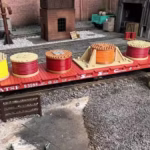 Side view of a cable drum load featuring multiple colorful spools in HO scale, displayed on a train car in a rail yard