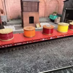 HO scale side view of a freight car loaded with colorful cable drums in a rail yard