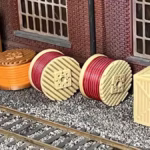 Side view of a HO scale cable drum load and a storage crate in a rail yard setting