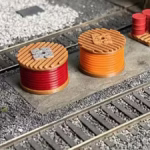 Top view of HO scale cable drum load featuring red and orange drums on a rail yard