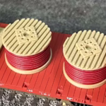 A top view of red cable drums on a freight car in HO scale.