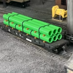 HO scale large pipe car load green corner view - ScaleRail3D