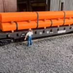 HO scale large pipe car load orange corner view - ScaleRail3D