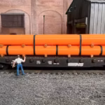 HO scale large pipe car load orange side view - ScaleRail3D